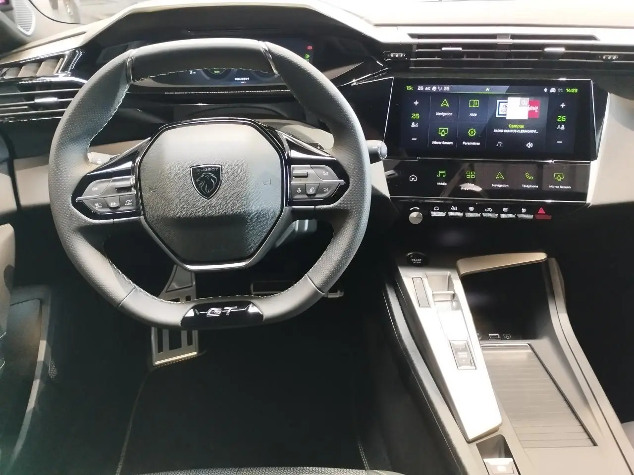 Vue intérieure centrée sur le volant GT cuir noir et l’écran tactile du tableau de bord de la Peugeot 308 gris selenium.
