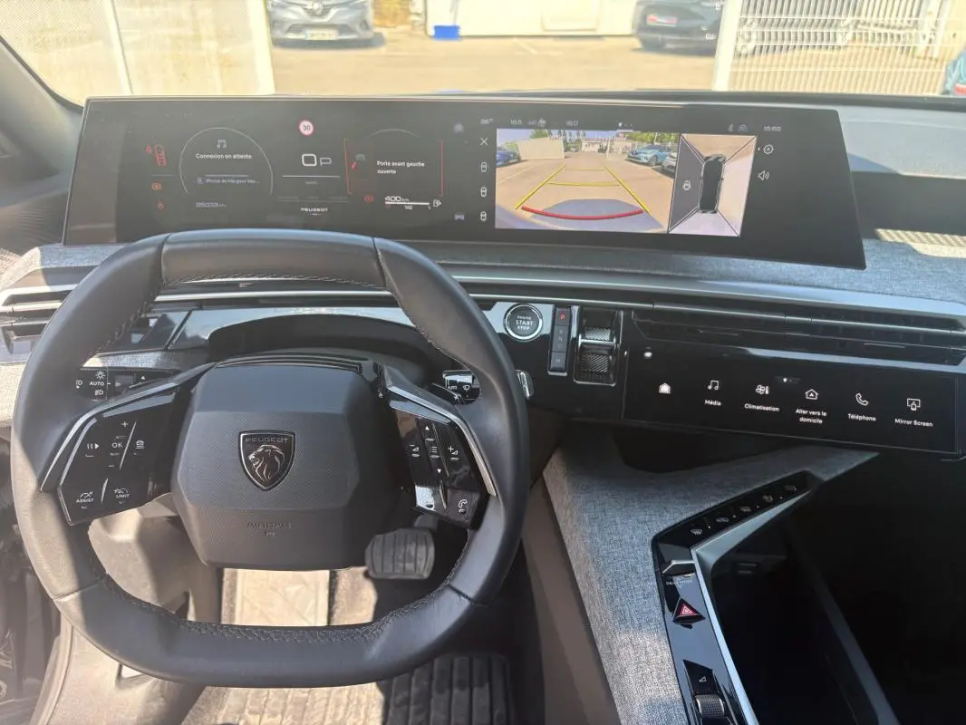 Vue intérieure du poste de conduite du Peugeot 3008 Hybrid 145 e-DCS6 Allure 2025, avec volant compact et écran numérique panoramique.