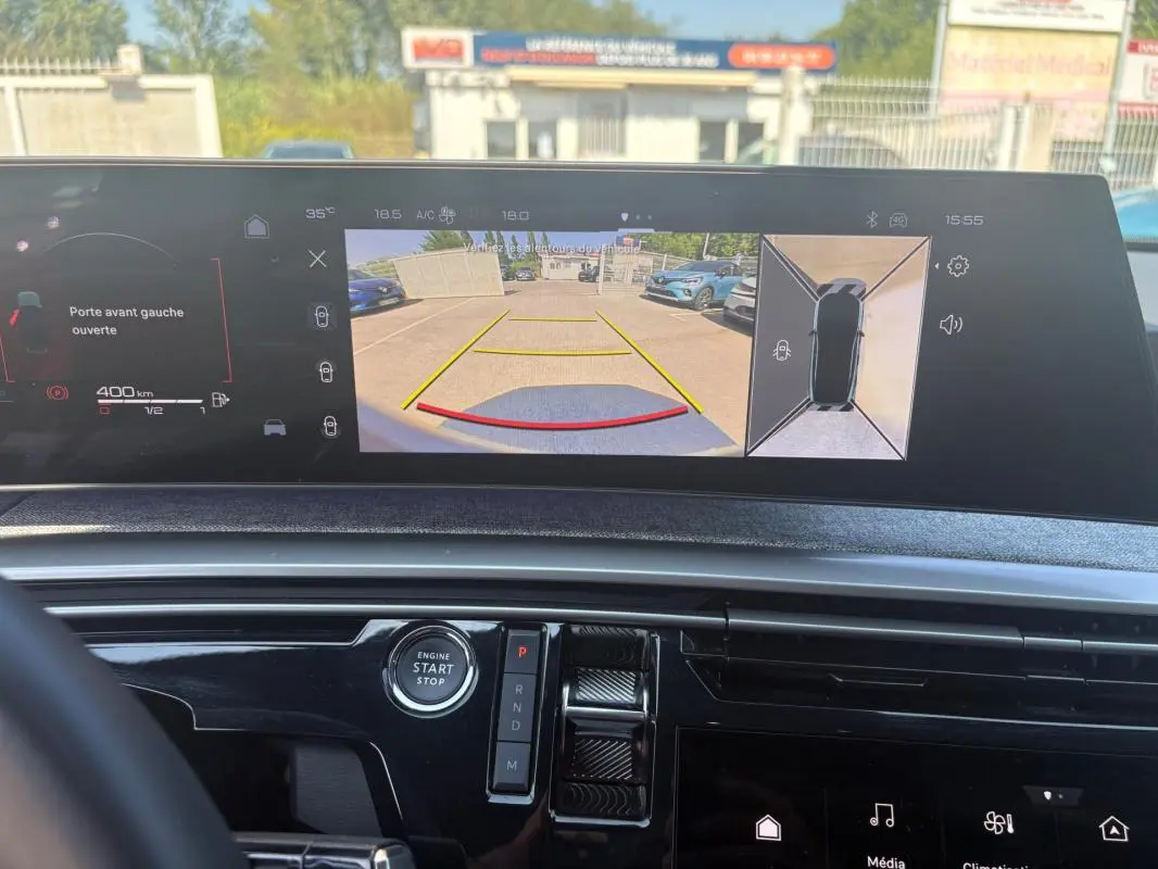Vue intérieure du cockpit numérique du Peugeot 3008 Hybrid 145 gris, affichant la caméra de recul et les commandes de boîte auto.