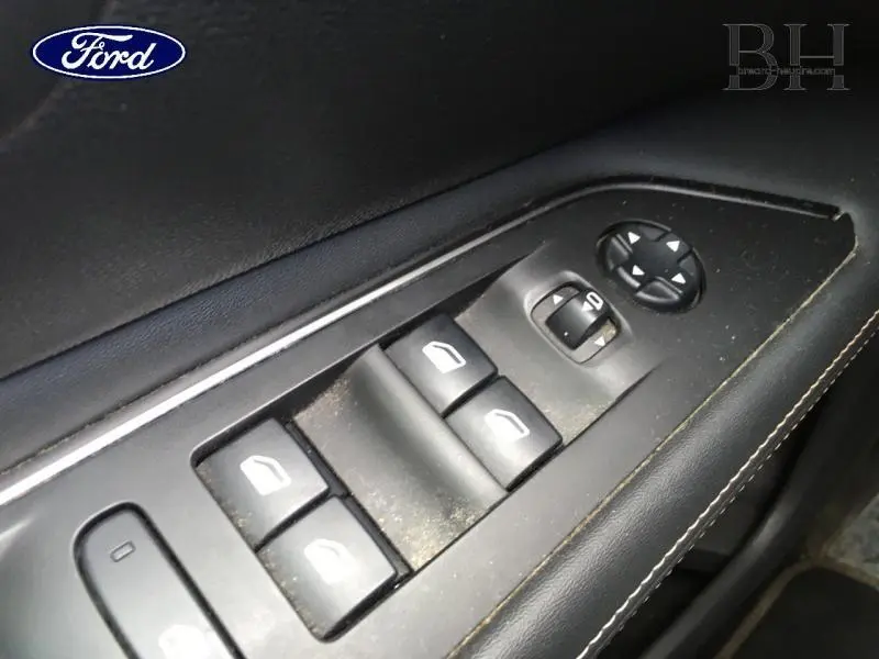 Gros plan sur les commandes électriques des vitres côté conducteur d'un Peugeot 3008 rouge Ultimate, intérieur noir.