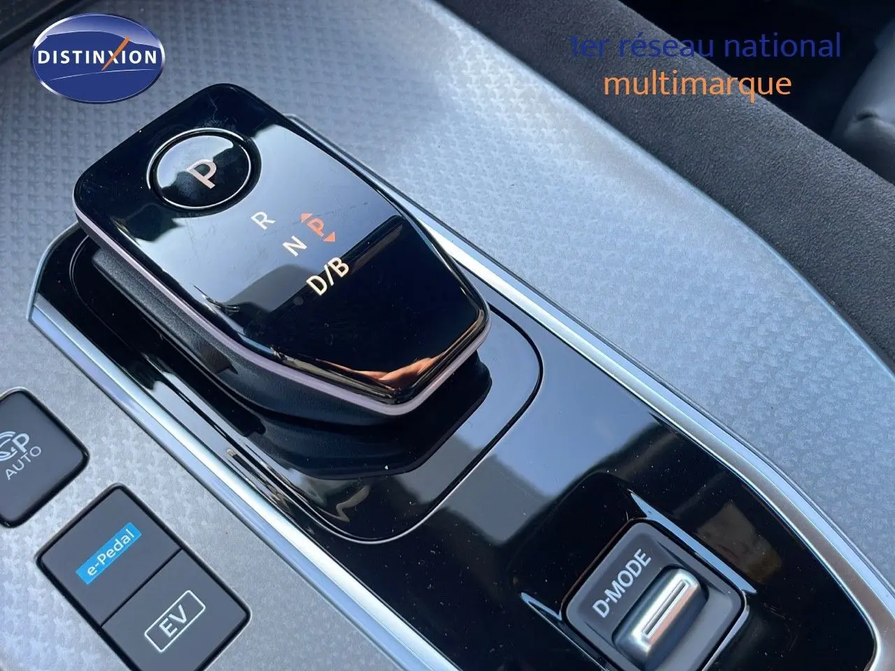 Gros plan sur la commande de boîte automatique noire brillante du Nissan Qashqai 2025, version hybride gris céramique.