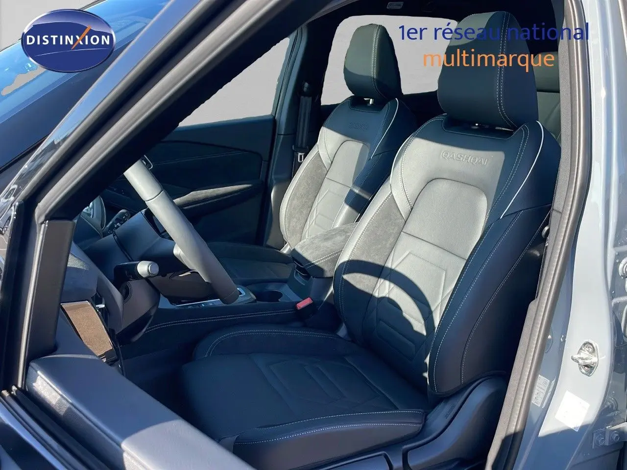 Intérieur du Nissan Qashqai 2025, sièges avant en cuir noir avec surpiqûres blanches, vue côté conducteur ouverte.