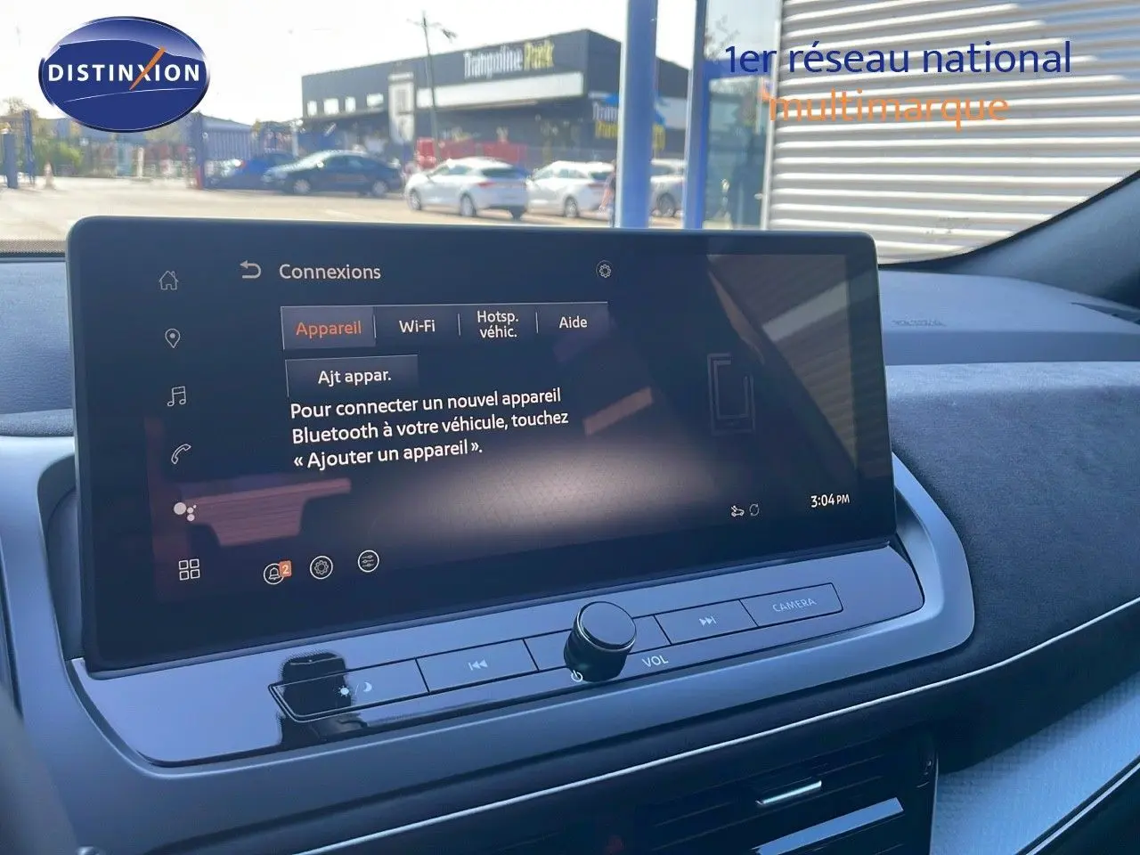 Écran tactile central du Nissan Qashqai 2025 en gros plan avec interface Bluetooth visible, intérieur moderne gris et noir.