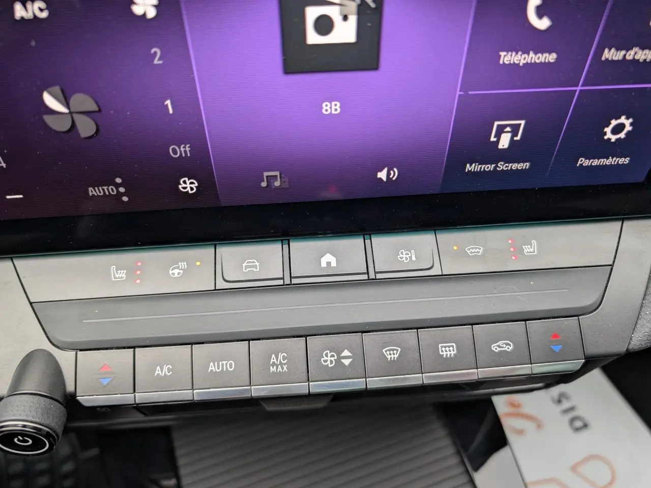 Gros plan sur la console centrale tactile de l'Opel Astra 2024, montrant les commandes de climatisation et sièges chauffants.