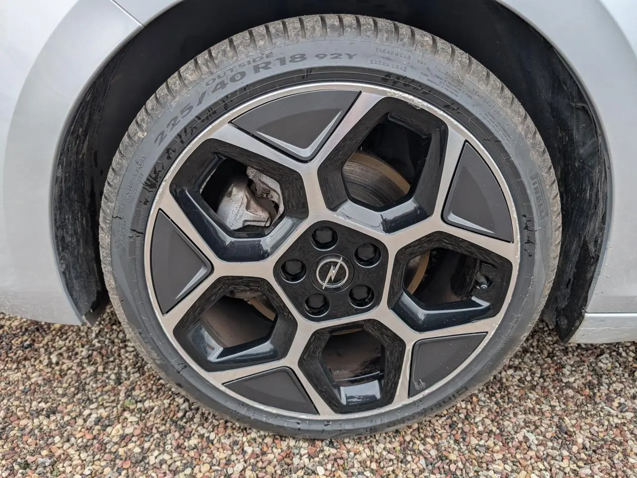Gros plan sur la jante alliage 18 pouces pentagonale diamantée noire et grise d'une Opel Astra gris métallisé 2024.