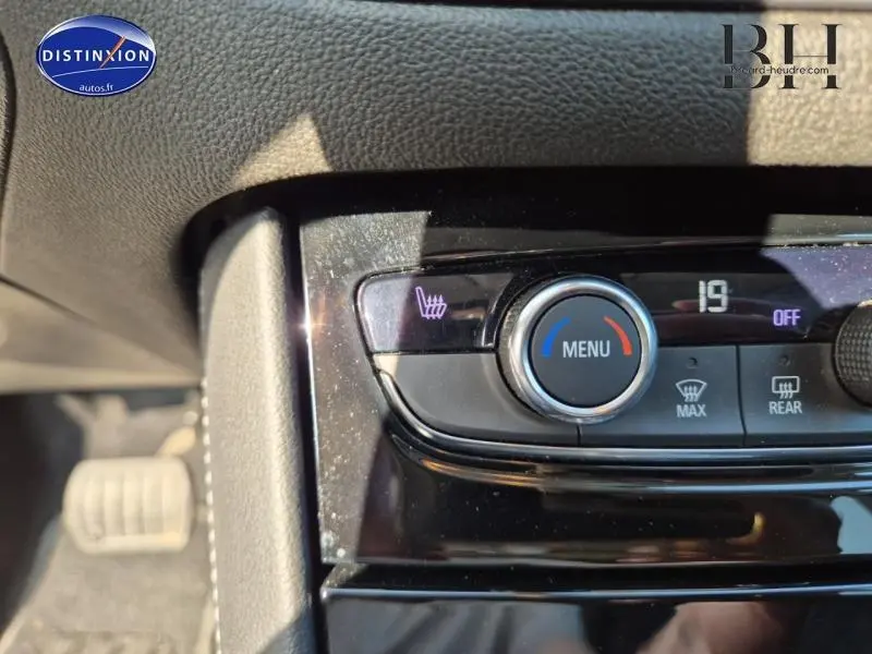 Gros plan sur la commande de chauffage de siège et réglage de climatisation du tableau de bord d’un Opel Grandland noir.
