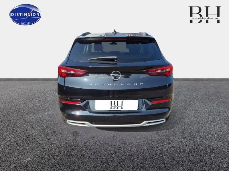 Vue arrière d'un Opel Grandland noir diamant métallisé avec feux arrière LED et logo central visible.