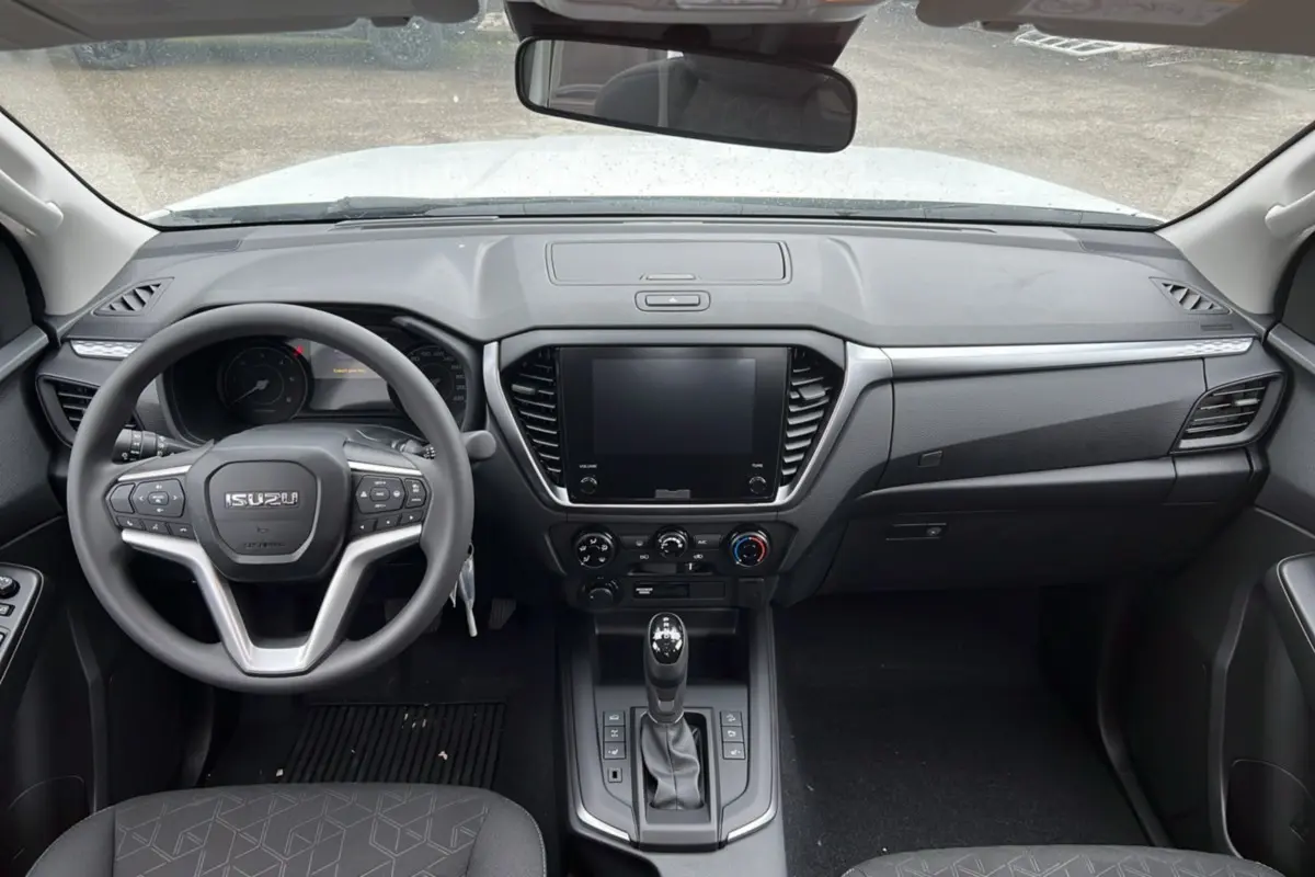 Vue intérieure frontale du tableau de bord noir et volant multifonctions de l'Isuzu D-MAX Splash White 2026.