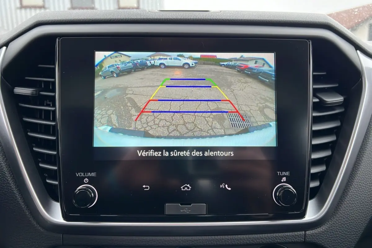 Écran central montrant la caméra de recul du pick-up Isuzu D-MAX blanc, avec lignes de guidage colorées.