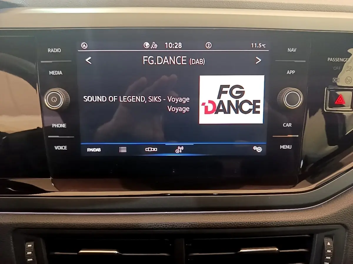 Écran tactile central du tableau de bord du Volkswagen Taigo noir, affichant la radio FG.DANCE en mode DAB.