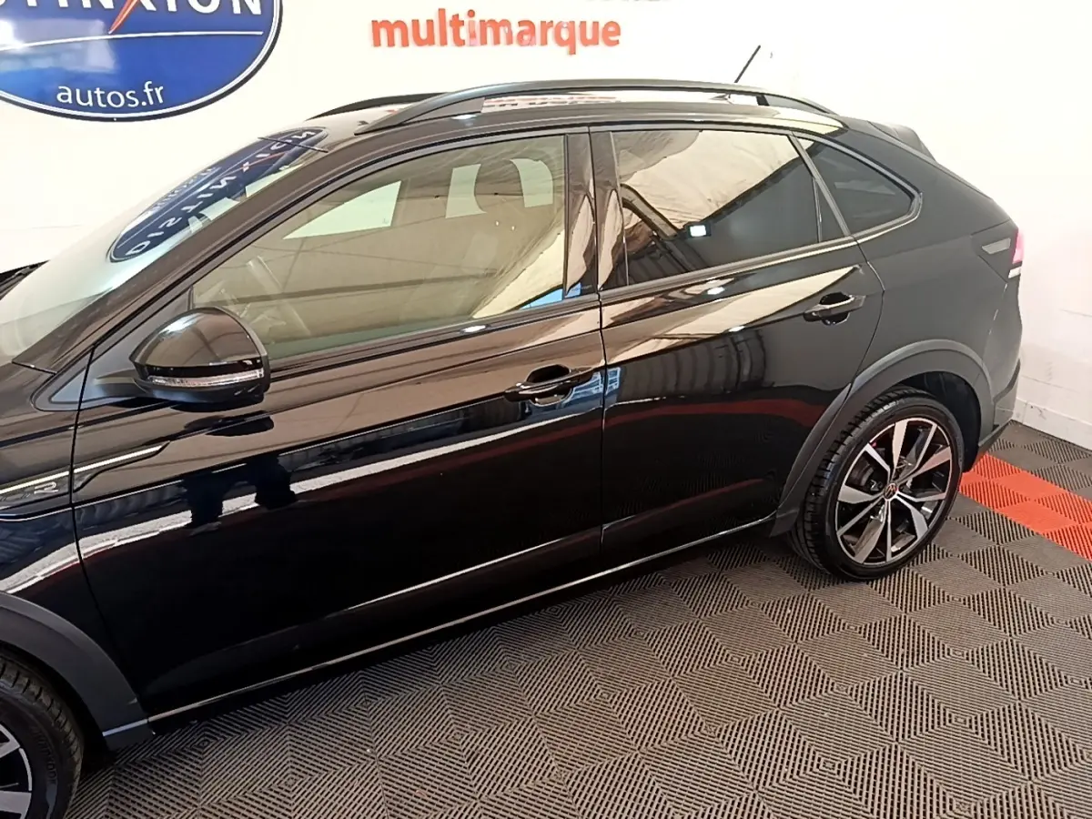 Profil droit du Volkswagen Taigo noir 2023 finition R-Line avec jantes alliage et rétroviseurs électriques.