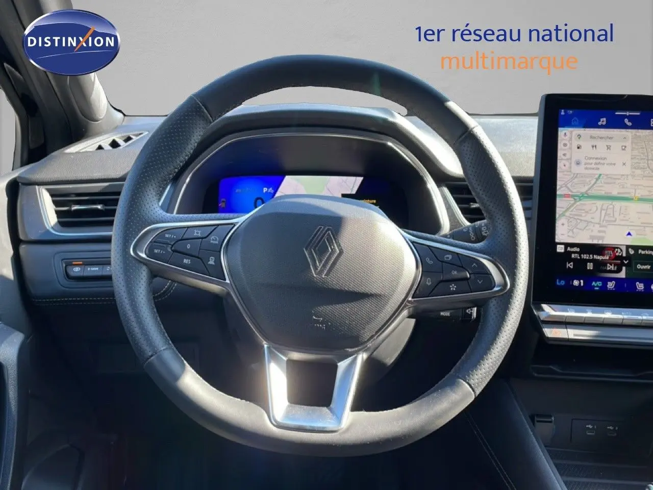 Vue frontale du volant noir perforé de la Renault Symbioz 2025 avec tableau de bord numérique et écran tactile de navigation.