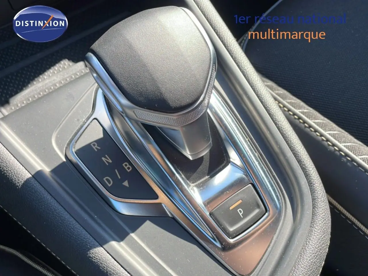 Gros plan sur la commande de boîte automatique noire et chrome du Renault Symbioz 2025, intérieur tissu noir visible.