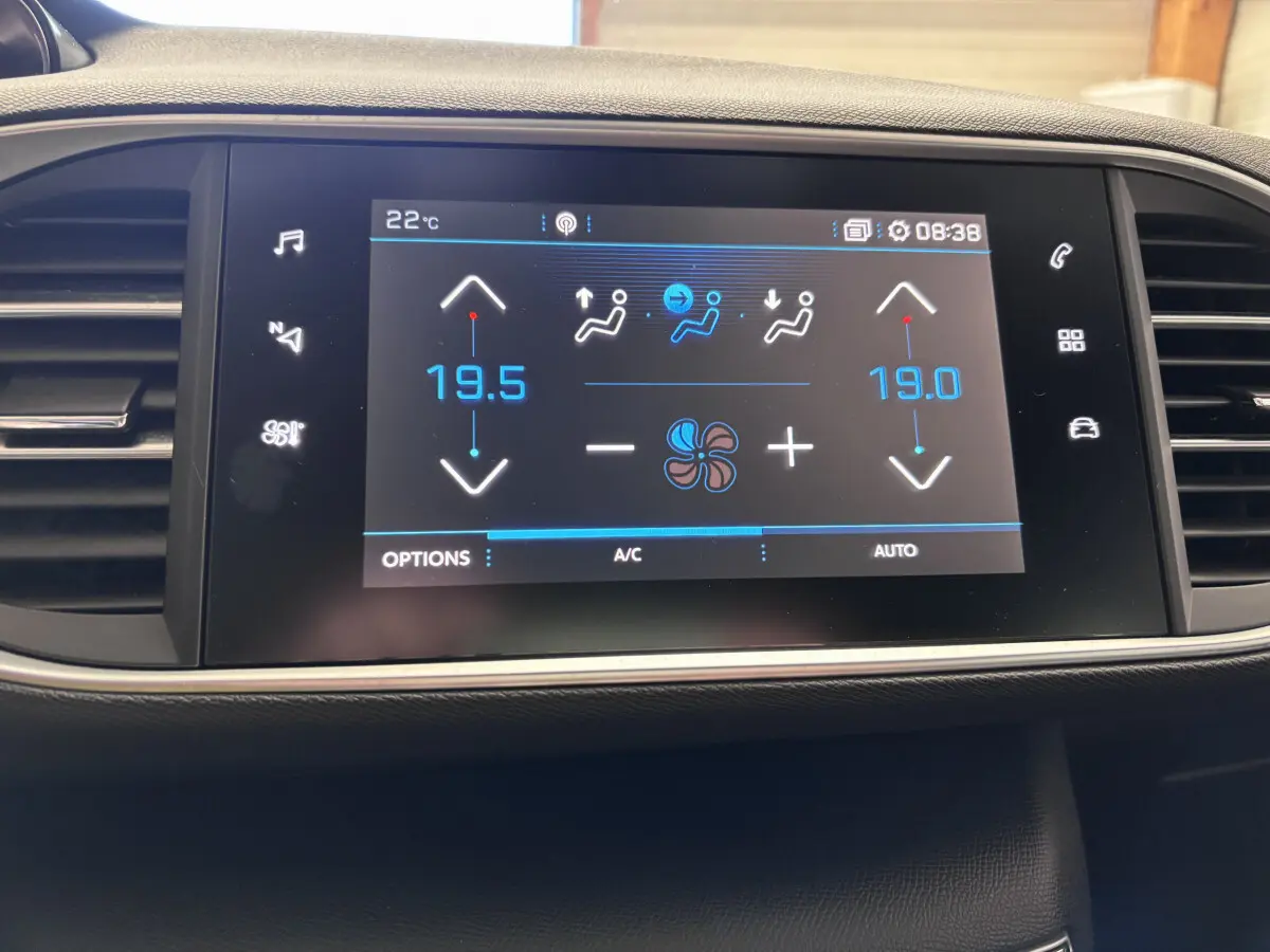 Écran tactile central de la Peugeot 308 gris foncé affichant la climatisation à 19,5°C côté gauche et 19°C côté droit.