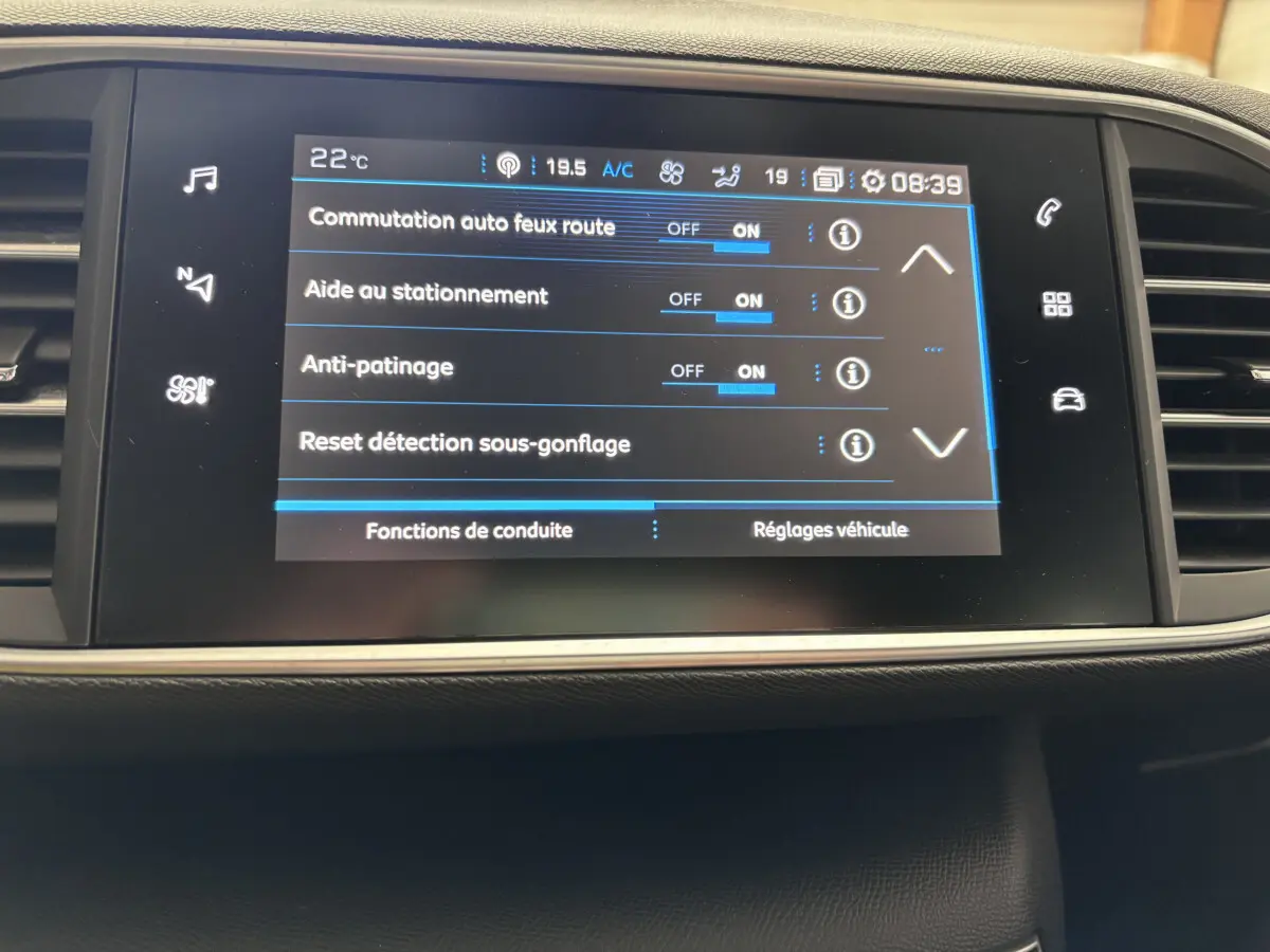 Écran tactile central de la Peugeot 308 gris foncé montrant les réglages d'aide à la conduite et sécurité.