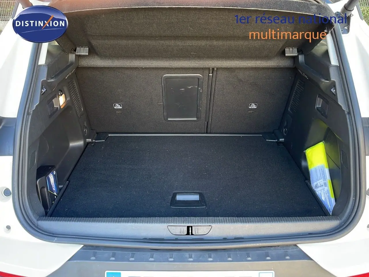 Coffre ouvert d'un Opel Grandland X blanc toit noir, vue arrière montrant un espace de chargement propre et spacieux.