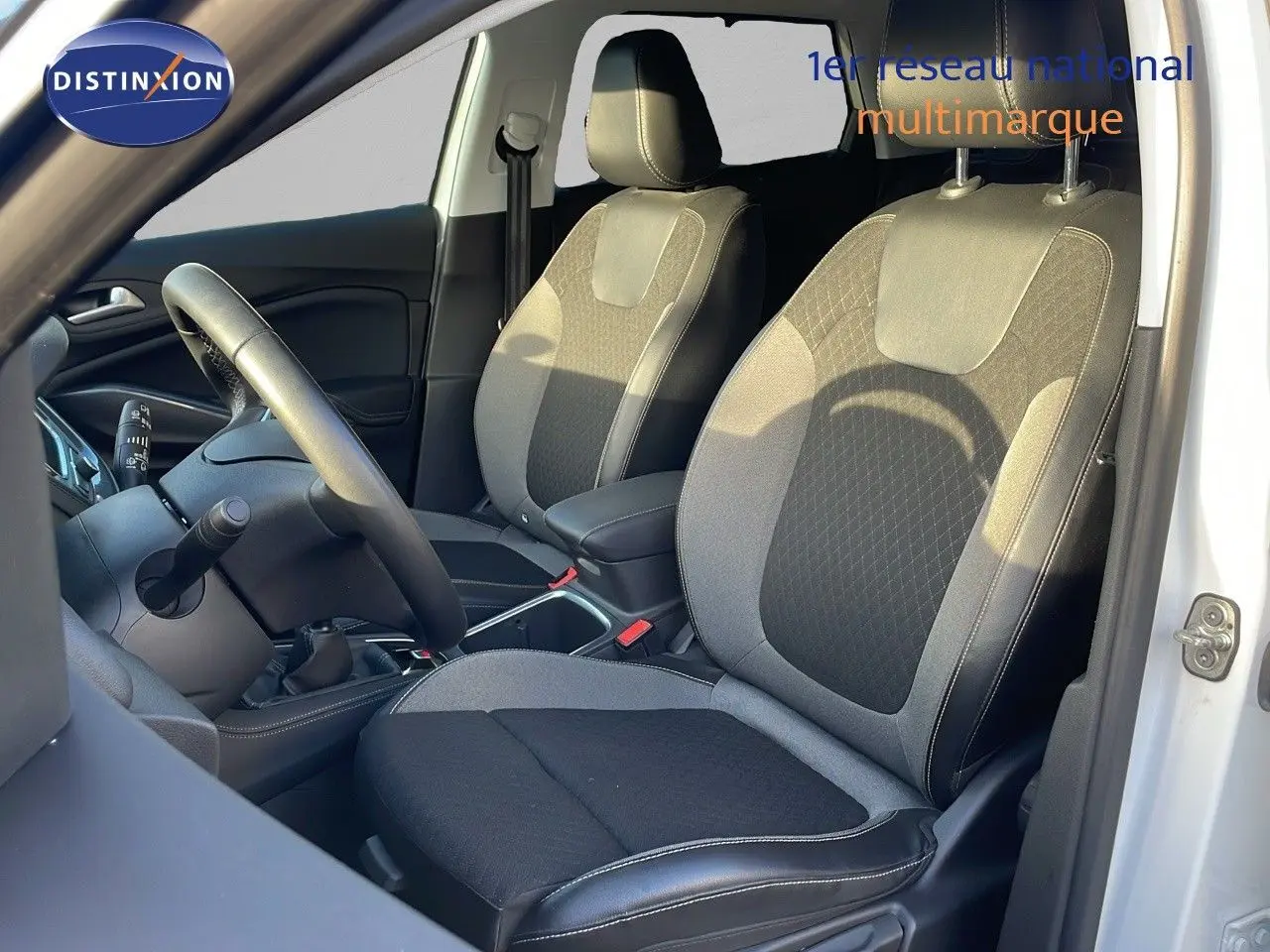 Intérieur avant droit de l'Opel Grandland X 2020 avec sièges tissu et cuir noir et gris, volant et levier de vitesses visibles.