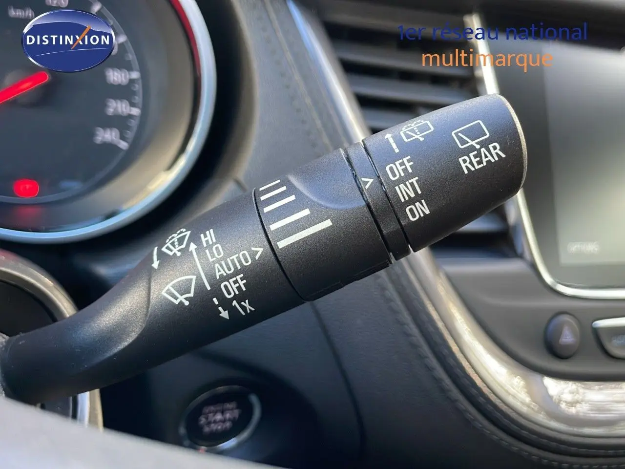 Gros plan sur la manette d'essuie-glace à gauche du volant dans l'habitacle d'un Opel Grandland X blanc toit noir.