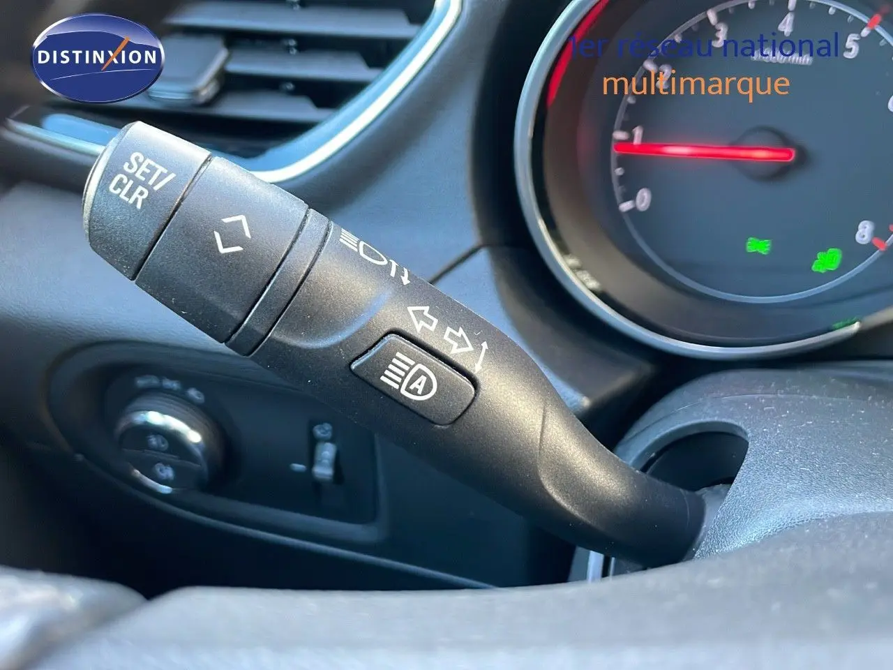 Gros plan sur la manette de clignotant et feux automatiques du tableau de bord d'un Opel Grandland X blanc toit noir.