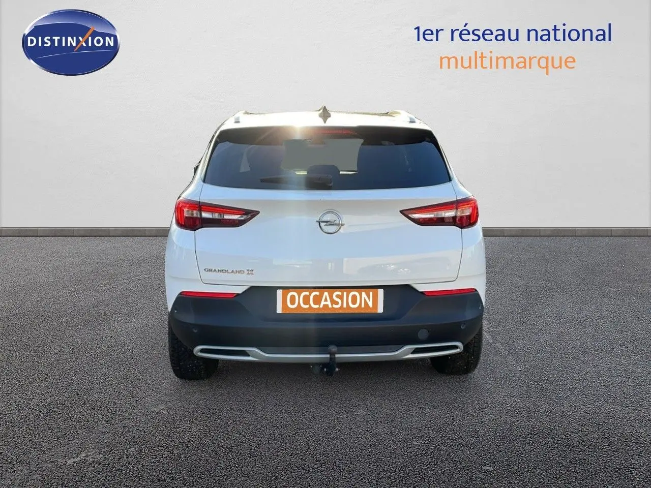 Vue arrière d'un Opel Grandland X blanc avec toit noir, équipé d'un attelage et d'une plaque "OCCASION".