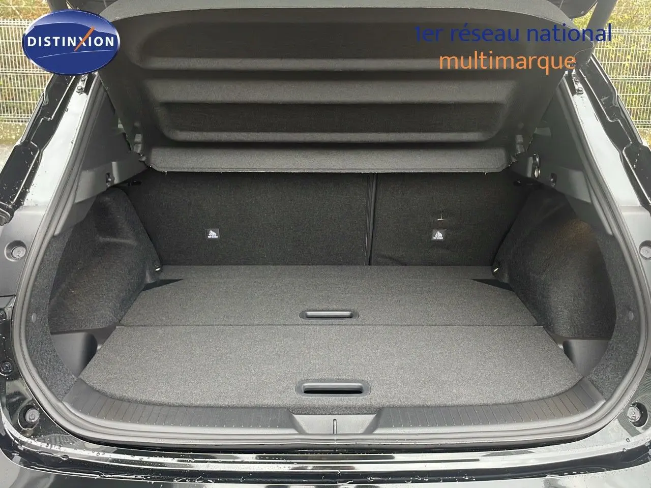 Coffre ouvert du Nissan Qashqai noir perle métal, vue arrière montrant l'espace de chargement plat et spacieux.