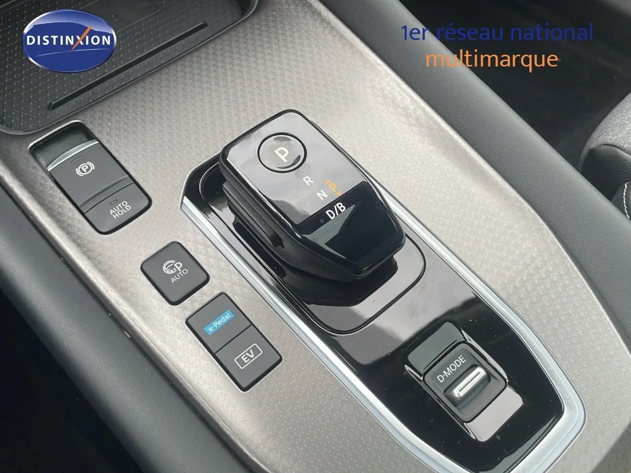 Gros plan sur la console centrale du Nissan Qashqai noir perle, mettant en valeur le sélecteur de boîte automatique et les boutons de conduite.