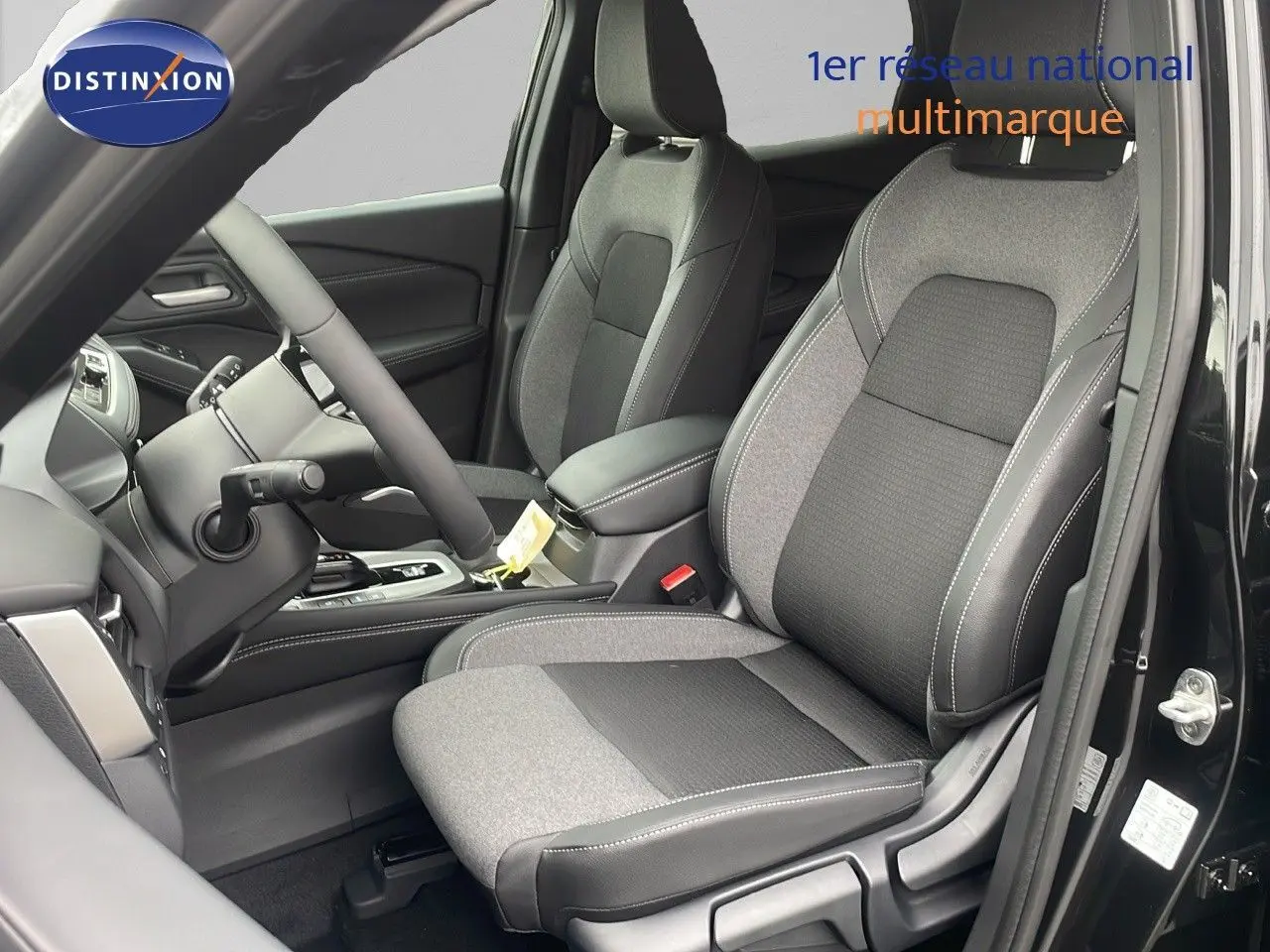 Intérieur du Nissan Qashqai 2025 noir perle, vue côté conducteur sur sièges tissu et cuir gris et noir.