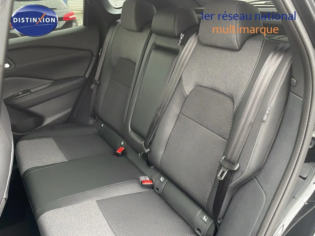 Vue intérieure sur les sièges arrière en tissu et cuir noir du Nissan Qashqai 2025, porte ouverte côté droit.