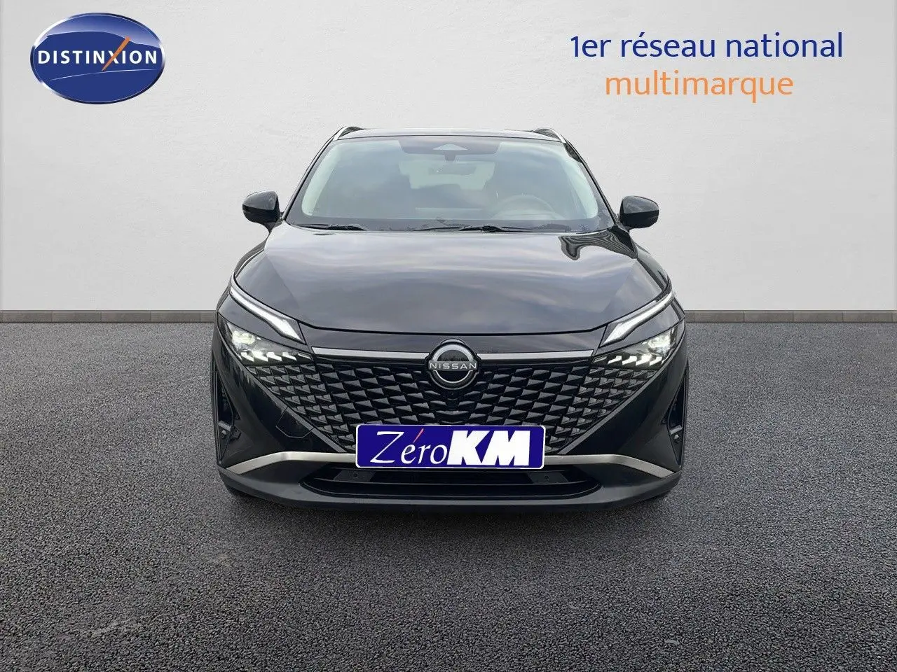 Vue frontale d'un Nissan Qashqai noir perle métal avec calandre à motifs géométriques et phares LED allumés.