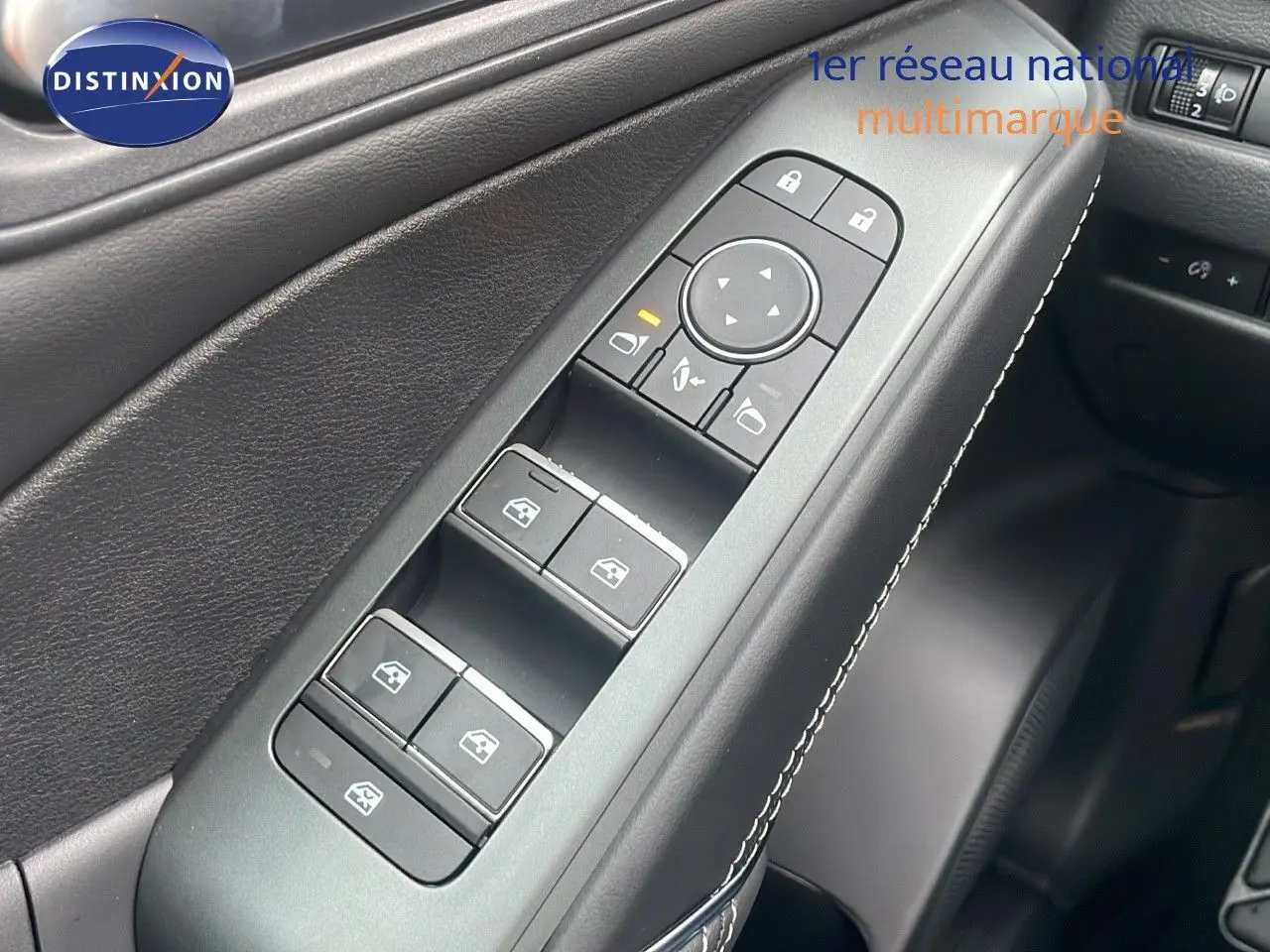 Gros plan sur la commande des vitres côté gauche en cuir noir avec surpiqûres blanches dans un Nissan Qashqai 2025 noir perle métal.