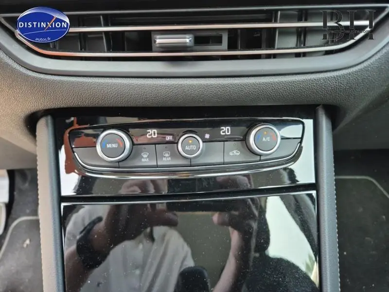 Vue rapprochée de la console centrale noire brillante de l'Opel Grandland 2023 avec commandes de climatisation automatique bi-zone.