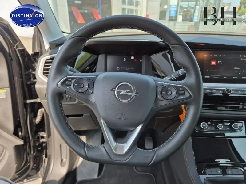 Volant cuir multifonction noir de l'Opel Grandland 2023, vue frontale du poste de conduite avec tableau de bord digital et écran tactile.
