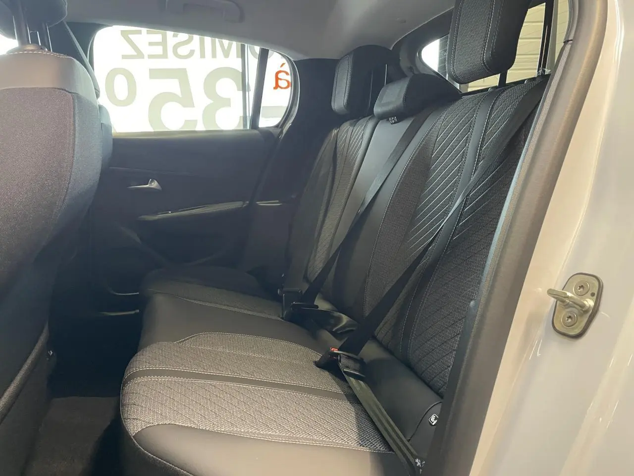 Vue intérieure côté droit de la banquette arrière tissu gris avec surpiqûres sur Peugeot 208 blanc okenite 2025.