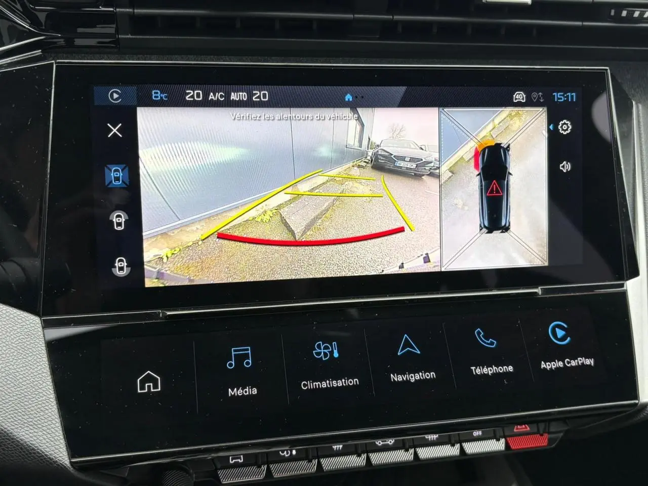 Écran tactile central affichant la caméra 360° avec vue arrière et alerte de proximité sur Peugeot 308 SW bleu cuivre.