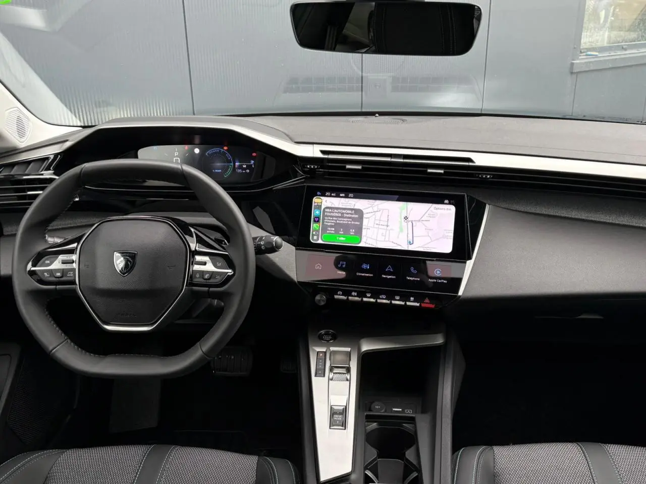Vue intérieure du poste de conduite de la Peugeot 308 SW Hybrid 145, avec écran tactile et volant compact noir.