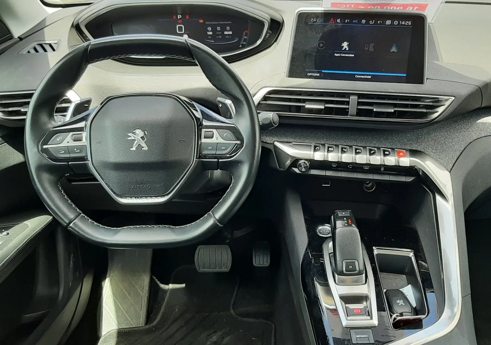 Vue intérieure du poste de conduite du Peugeot 3008 gris, avec volant compact, écran tactile central et levier de boîte automatique.