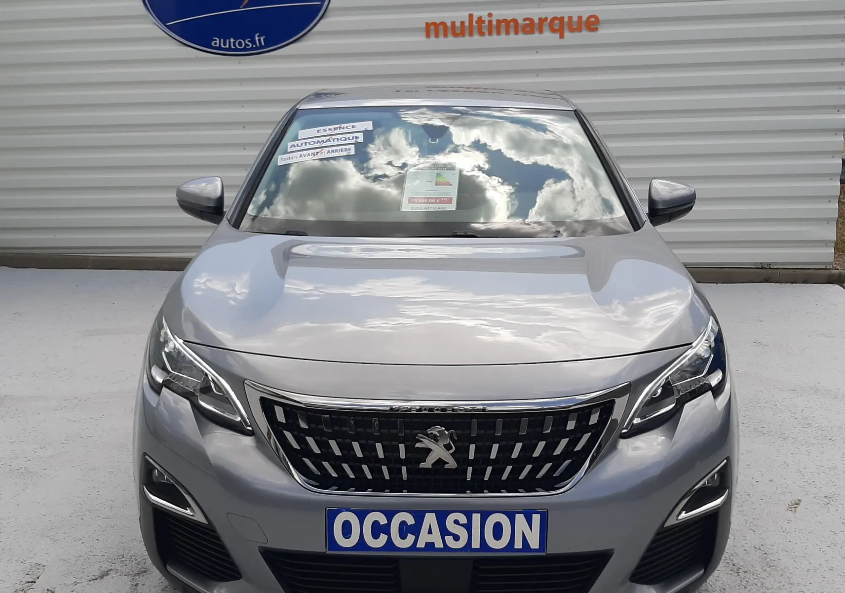Vue frontale d'un Peugeot 3008 gris 2020 avec calandre chromée et plaque "OCCASION" visible.