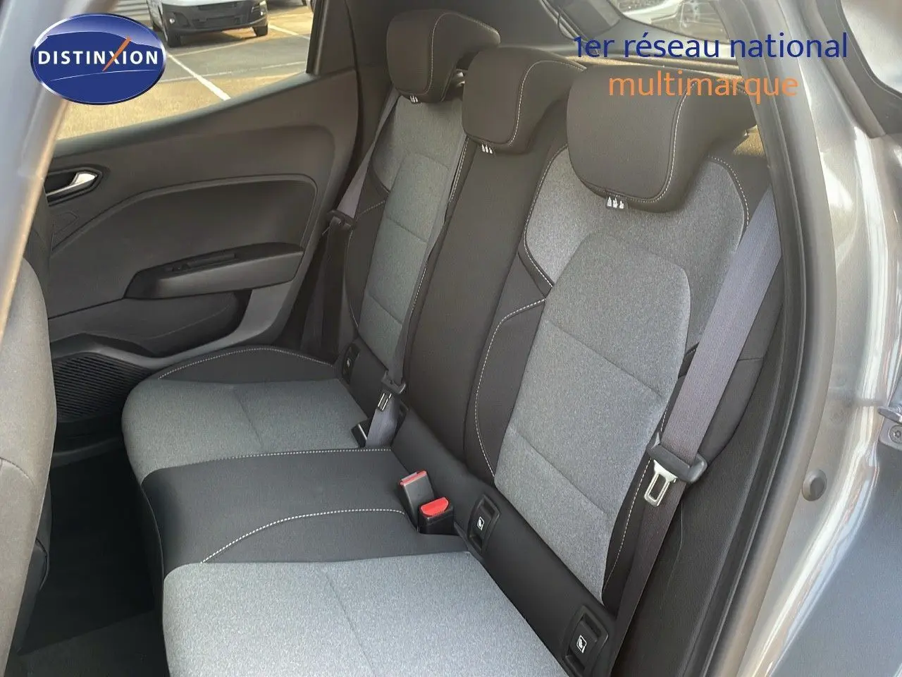 Vue intérieure de la banquette arrière gris clair et noir de la Renault Clio 1.5 DCI 2025 avec ceintures et porte ouvert côté droit.