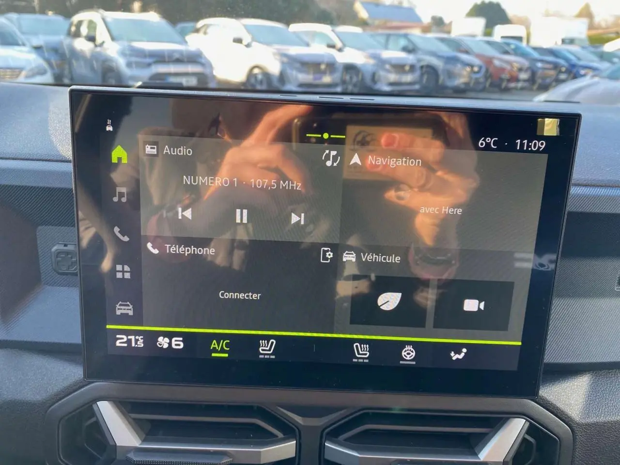 Écran tactile central du tableau de bord du Dacia Duster 2024, affichant radio et navigation, intérieur moderne.