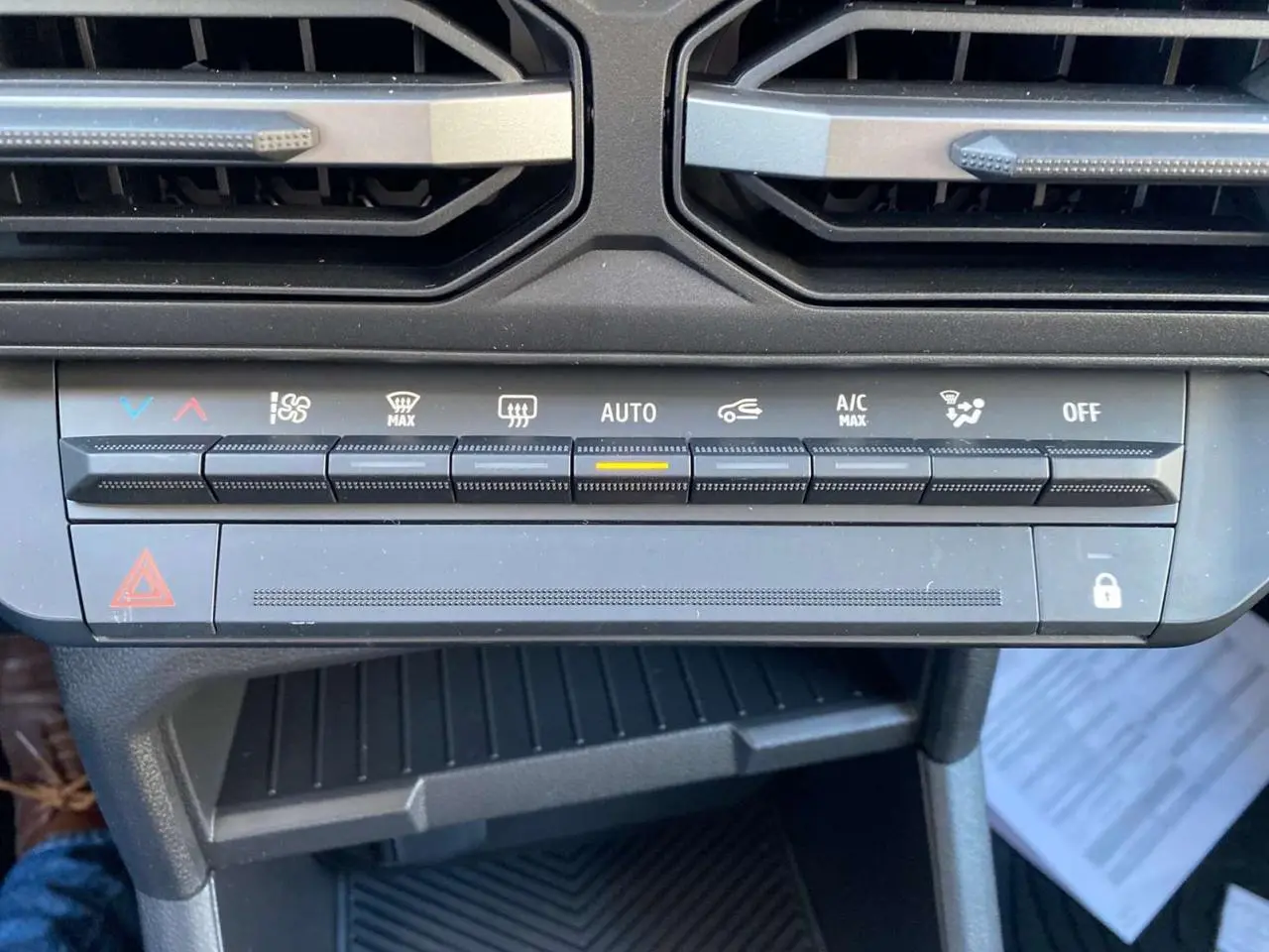 Gros plan sur la console centrale du Dacia Duster 2024 montrant les commandes de climatisation automatique.