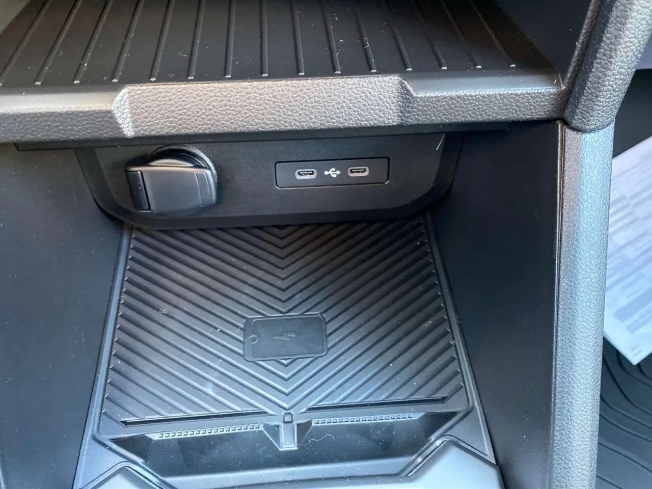 Gros plan sur la console centrale arrière du Dacia Duster 2024 avec prises USB type C et prise 12V noire.