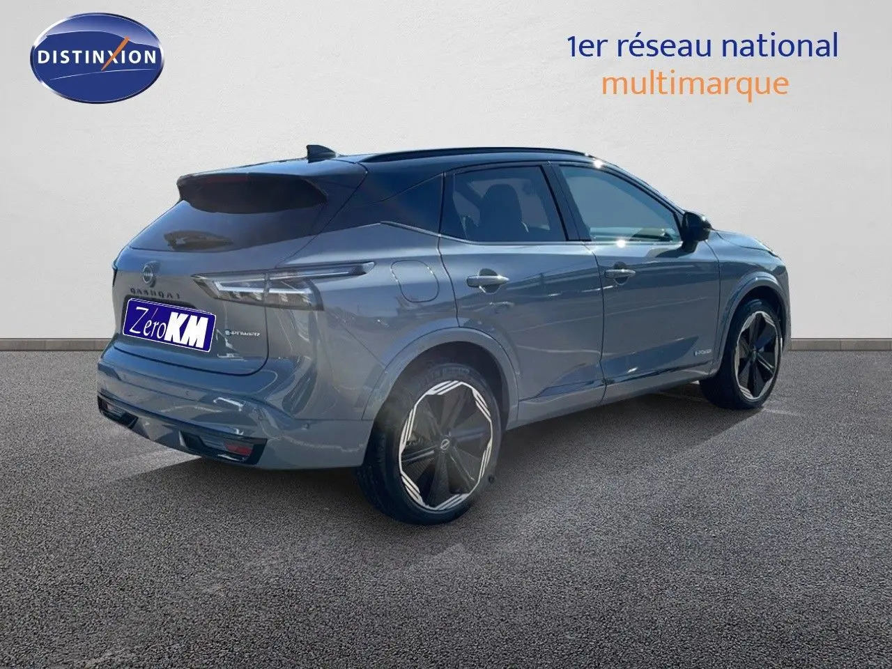 Vue 3/4 arrière droite d'un Nissan Qashqai 2025 gris céramique métal avec toit noir et jantes stylisées noires.