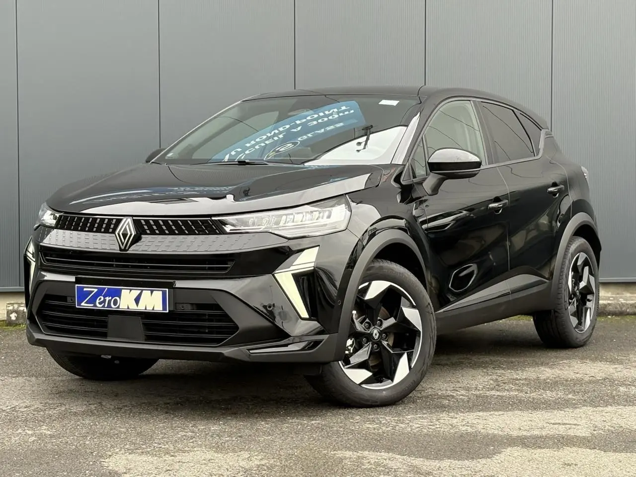 Renault Captur 2025 noir étoilé en vue 3/4 avant droit, avec jantes aluminium noires et signature lumineuse LED.