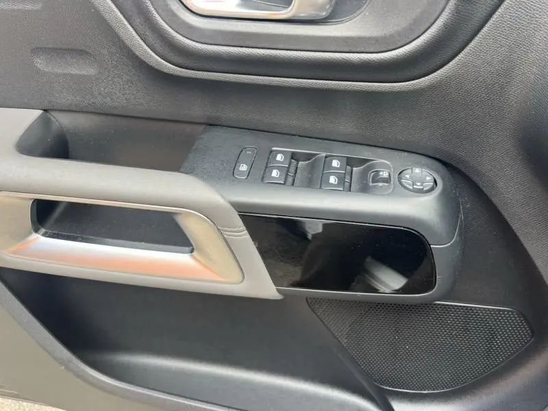 Gros plan sur la commande des vitres et rétroviseurs côté gauche de la porte intérieure noire du Citroën C5 Aircross Blanc Banquise.