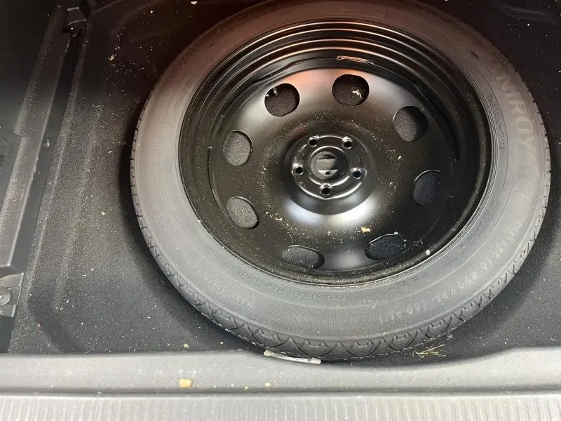 Roue de secours noire vue de dessus dans le coffre d'une Citroën C5 Aircross Blanc Banquise 2020