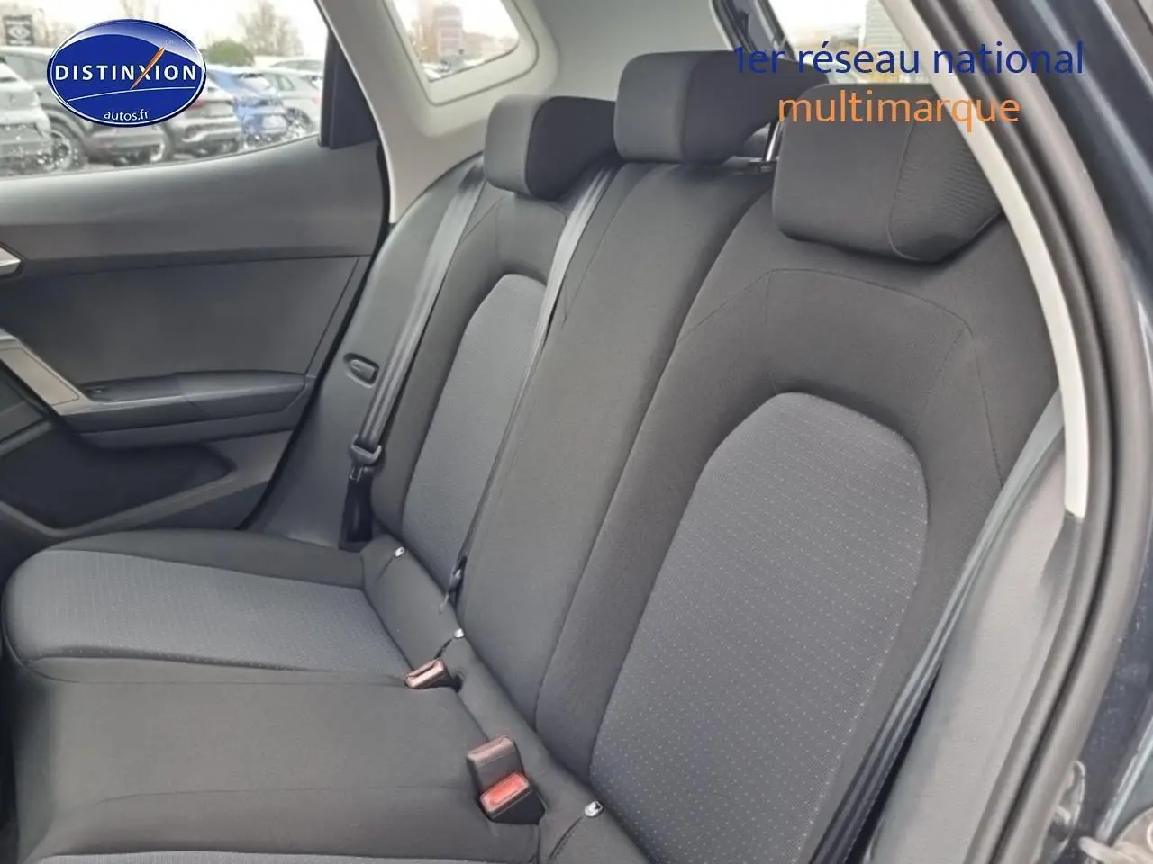 Vue intérieure sur la banquette arrière en tissu gris du SEAT Arona 2025, porte arrière ouverte côté droit.