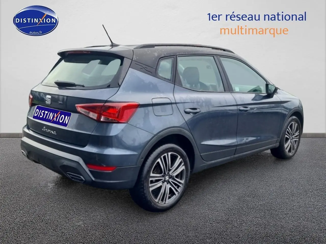 Vue 3/4 arrière droite d'une SEAT Arona gris magnétique avec jantes 17 pouces et barres de toit visibles.