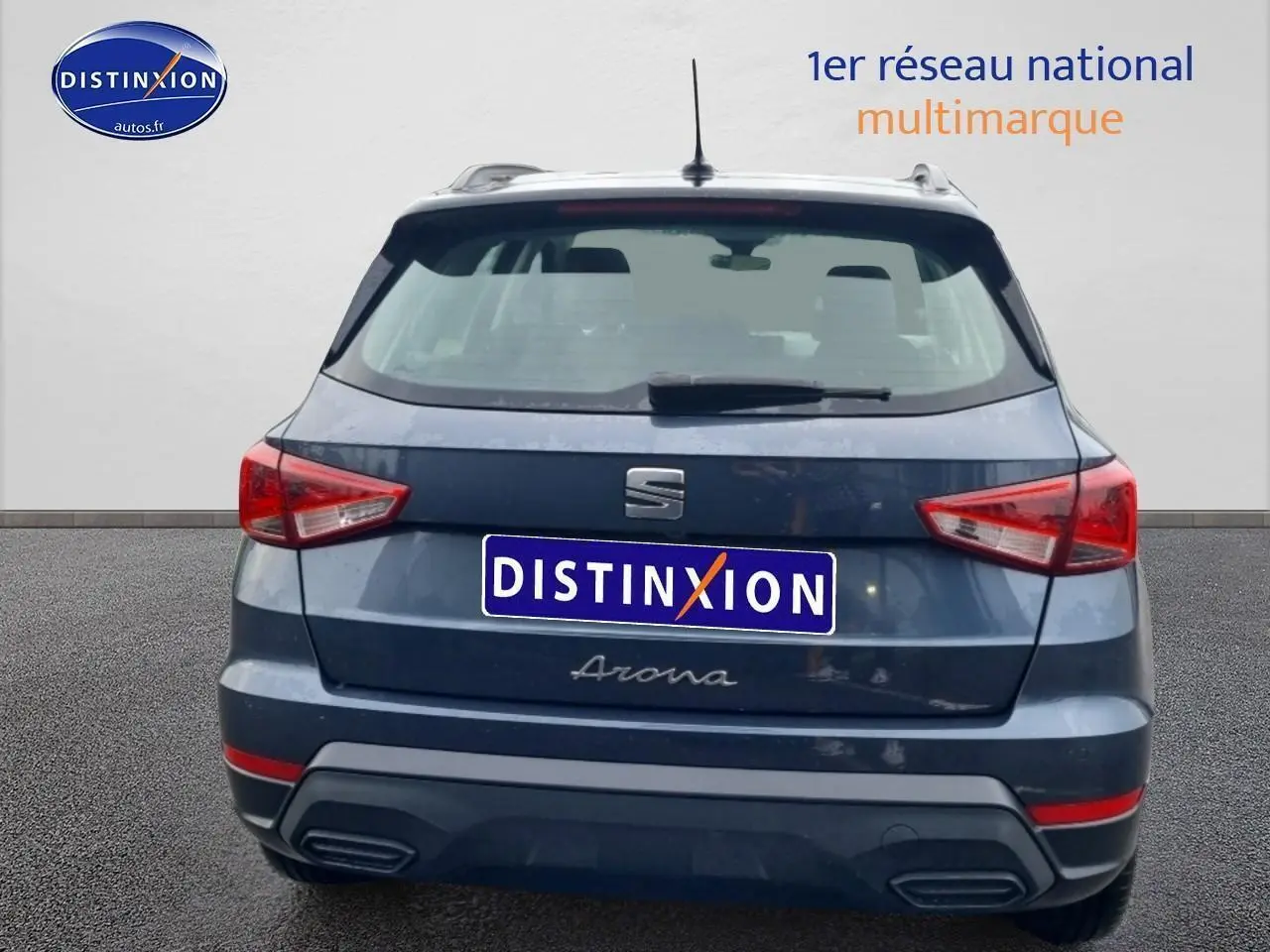 Vue arrière d’un SEAT Arona gris magnétique avec feux triangulaires et barres de toit visibles.