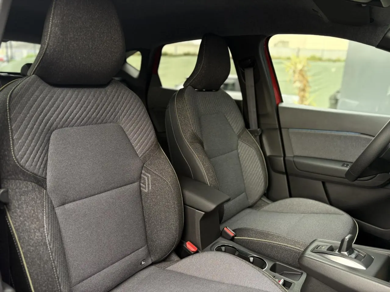 Vue intérieure côté gauche des sièges avant gris anthracite du Renault Captur 2025 avec console centrale et levier de vitesses.