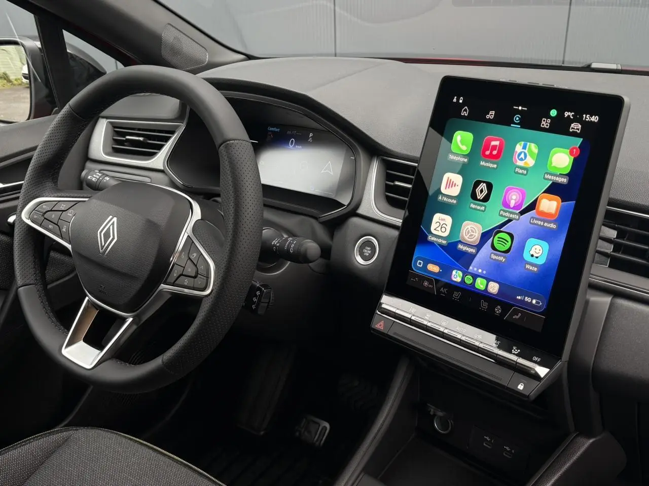 Vue intérieure côté conducteur du Renault Captur 2025, avec volant multifonction et grand écran tactile vertical.